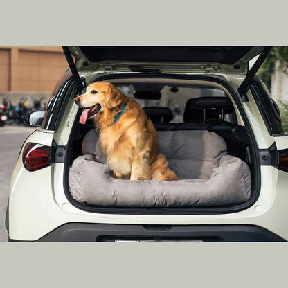 Chien Golden Retriever assis dans une housse de siège auto grise Cloud de Pitou et moi, installée dans le coffre d'un SUV.