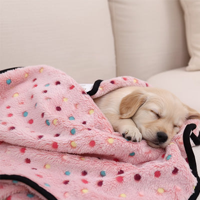 chiot golden retriever couché confortablement dans la couverture pour chien La doudou en polaire rose.