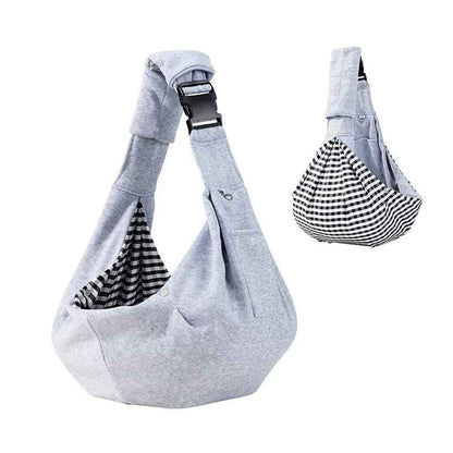 Sac de transport pour chien Chien de Poche en version grise, montrant le design réversible avec une doublure en tissu à carreaux noir et blanc (vichy) et la boucle de sécurité ajustable.