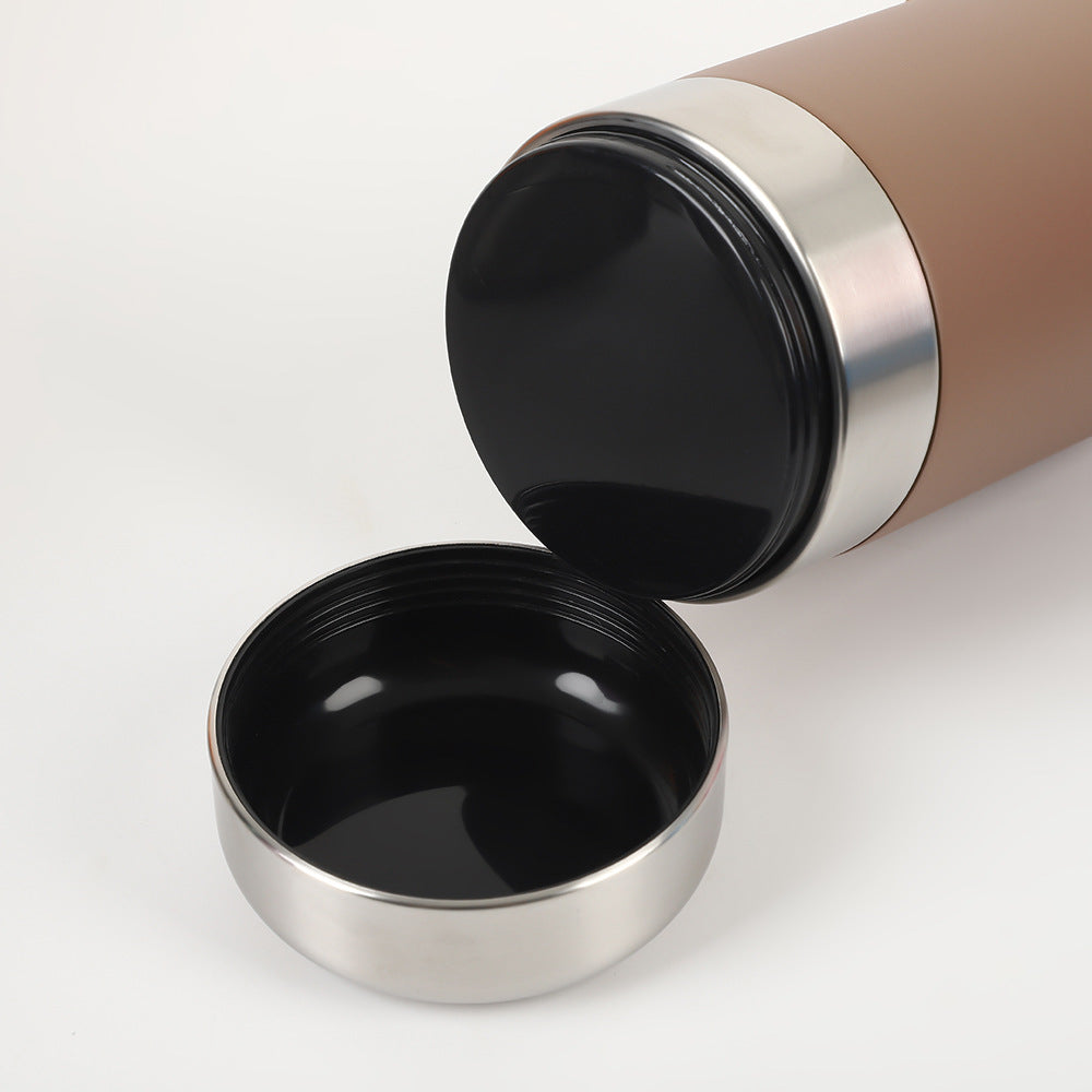 Détail du couvercle amovible de la gourde La Rafraîchissante utilisé comme bol abreuvoir pour chien, posé à côté de la bouteille en acier inoxydable.