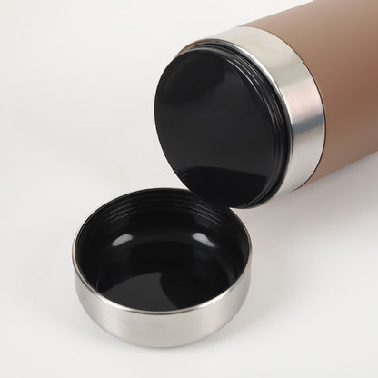 Détail du couvercle amovible de la gourde La Rafraîchissante utilisé comme bol abreuvoir pour chien, posé à côté de la bouteille en acier inoxydable.