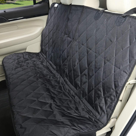Vue d'ensemble de la housse de voiture CozyCar noire installée sur une banquette arrière, montrant la texture matelassée résistante et les sangles de fixation réglables autour des appuie-têtes.
