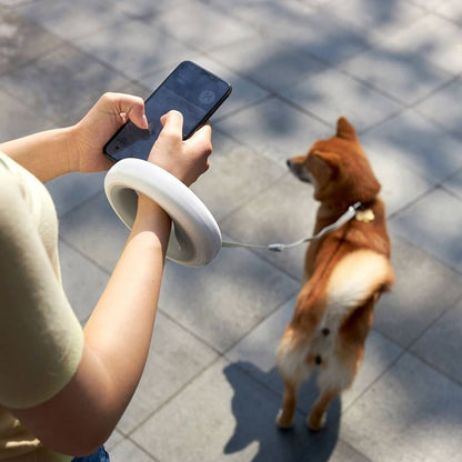 Laisse poignet mains libres pour petit chien, enrouleur rétractable blanc au design circulaire, idéal pour envoyer des messages ou téléphoner en promenant son animal, boutique Pitou et moi.