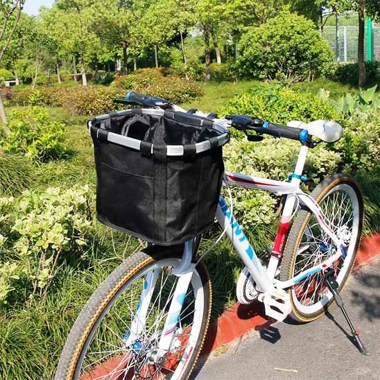 Panier de vélo amovible Sécuriride en tissu noir installé sur un vélo de ville blanc, illustrant la fixation facile au guidon et le design spacieux pour petit chien ou commissions.
