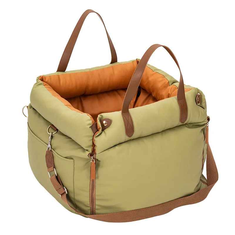 Sac de transport pour chien Cocon Voyageur, coloris vert kaki avec intérieur orange molletonné, installé comme siège auto sécurisé pour petit chien.