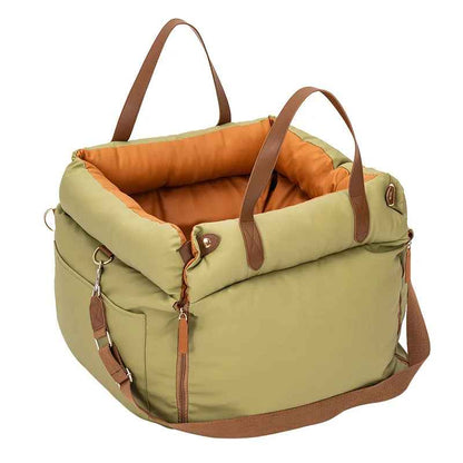 Sac de transport pour chien Cocon Voyageur, coloris vert kaki avec intérieur orange molletonné, installé comme siège auto sécurisé pour petit chien.