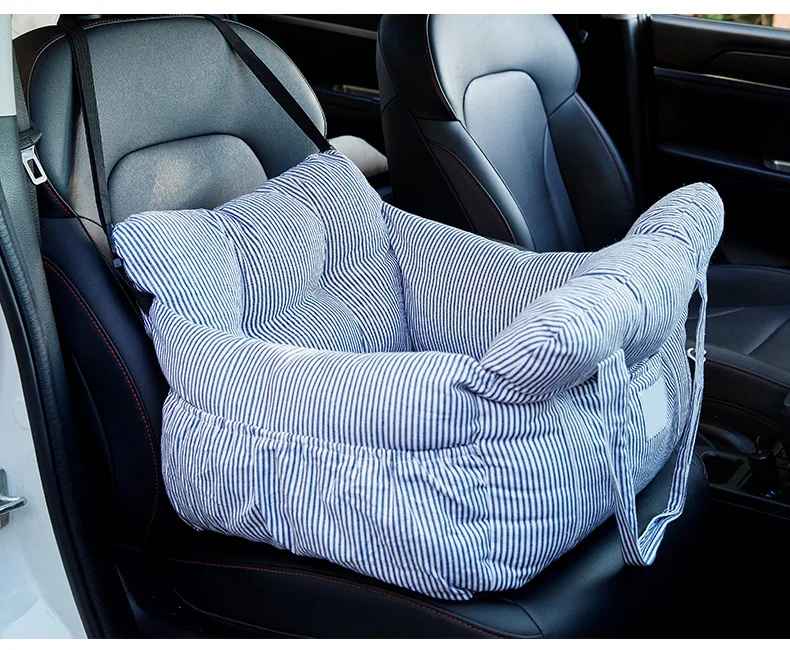 Sac de transport pour chien Cocon Voyageur à rayures bleues et blanches, installé sur un siège de voiture en cuir noir comme panier de sécurité