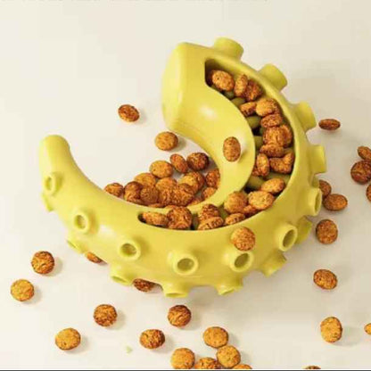 Vue rapprochée du jouet Zen-Mâch jaune rempli de croquettes, utilisé comme distributeur de nourriture interactif pour ralentir la prise alimentaire du chien.